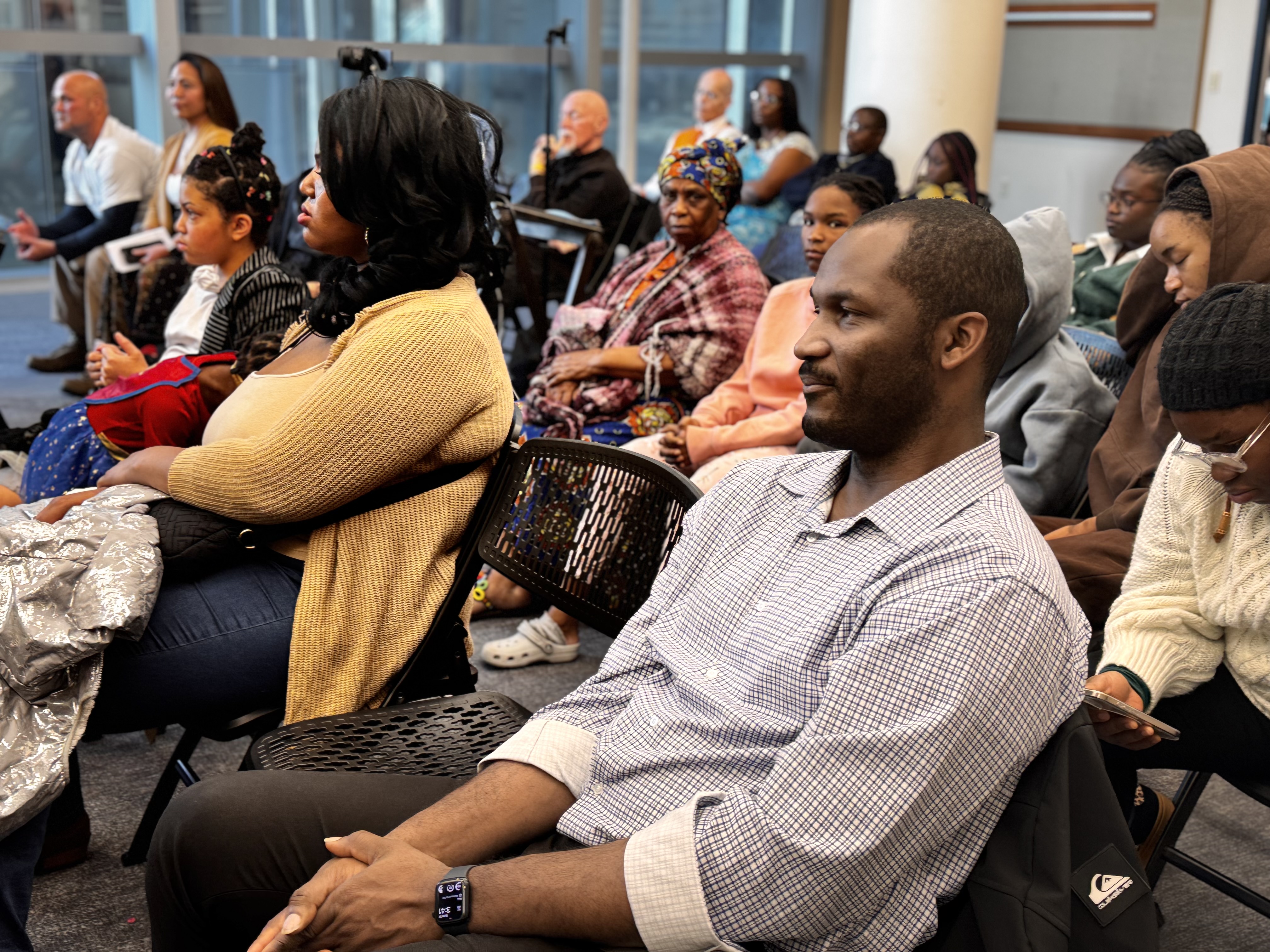 A diverse community gathers to listen and share at Ọgbaniko